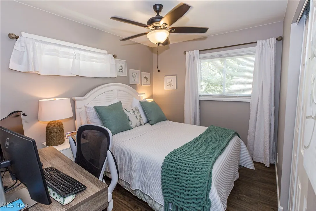 Bedroom featuring wood finished floors, a ceiling fan, and an office area