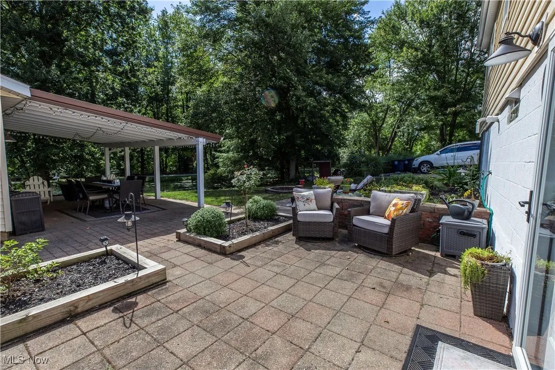 View of patio featuring outdoor dining space, a vegetable garden, a deck, and an outdoor hangout area