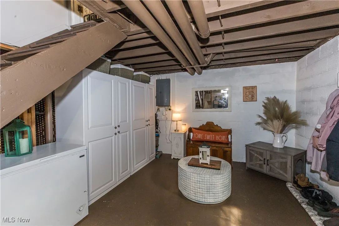 Sitting room with finished concrete floors and electric panel