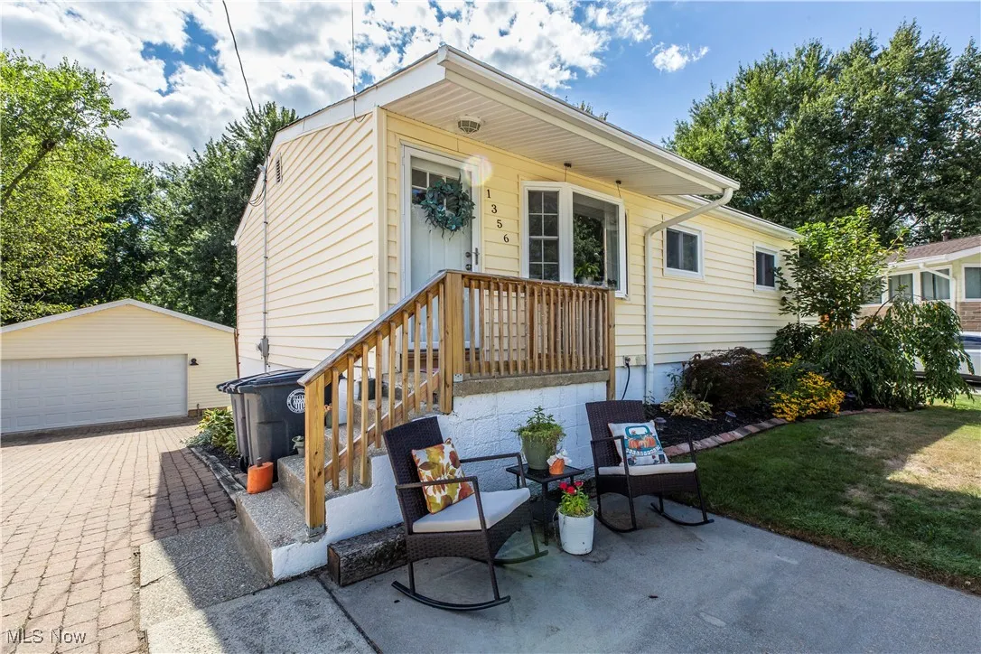 View of front of house featuring an outdoor structure, a patio, a garage, and a front yard