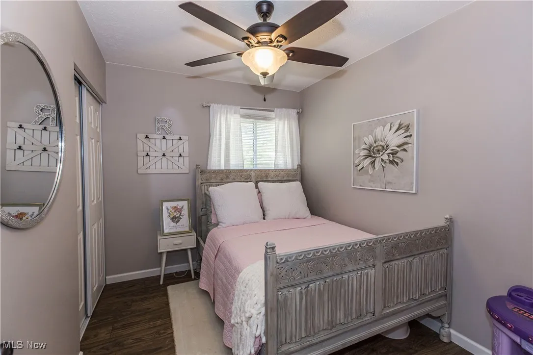 Bedroom featuring dark wood-type flooring, a closet, and a ceiling fan