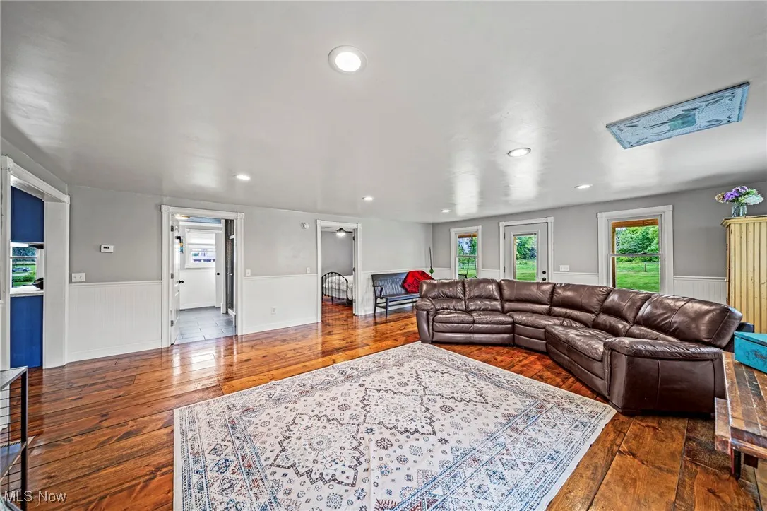Living area with wainscoting, dark wood-style floors, and recessed lighting