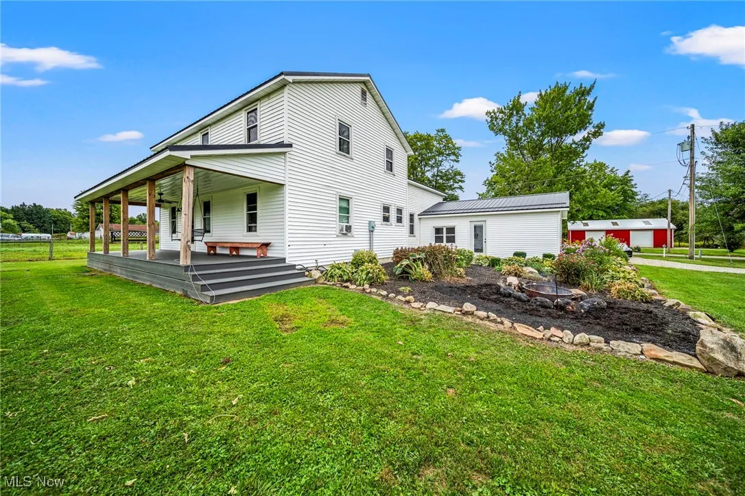 Back of property featuring a yard and a porch