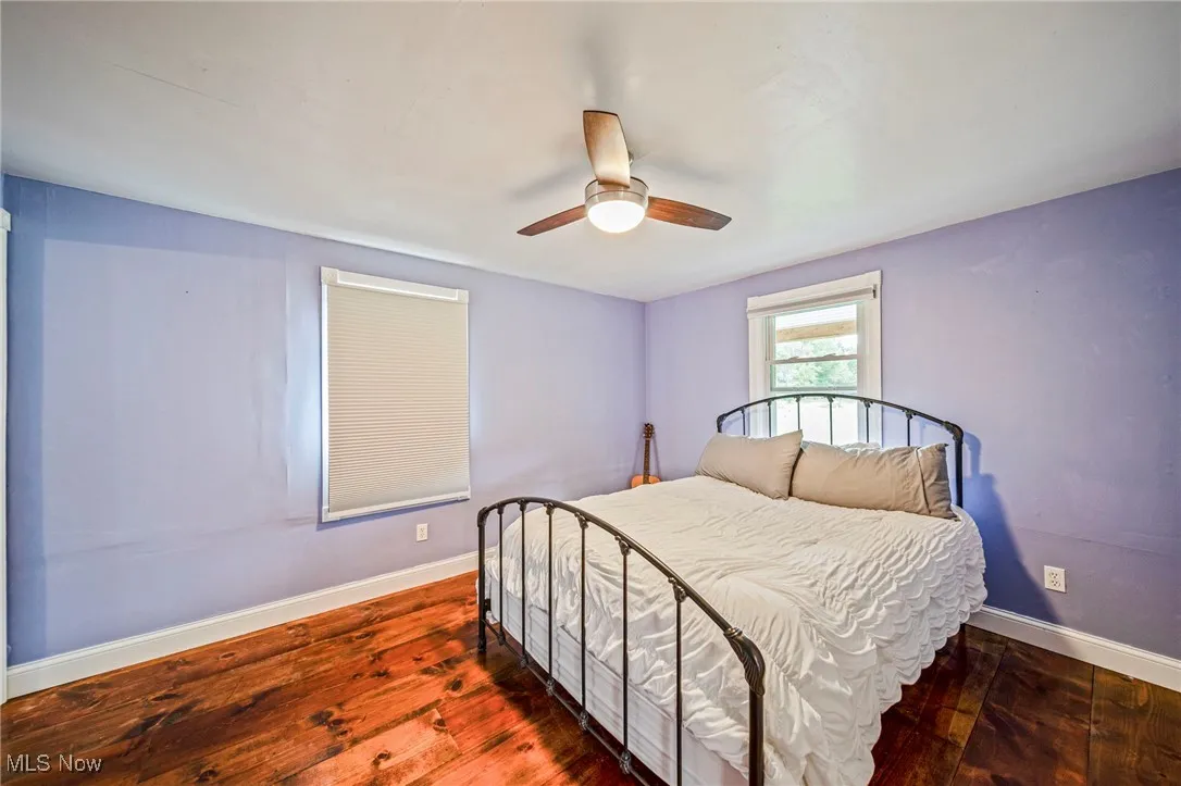 Bedroom with dark wood-style floors and a ceiling fan