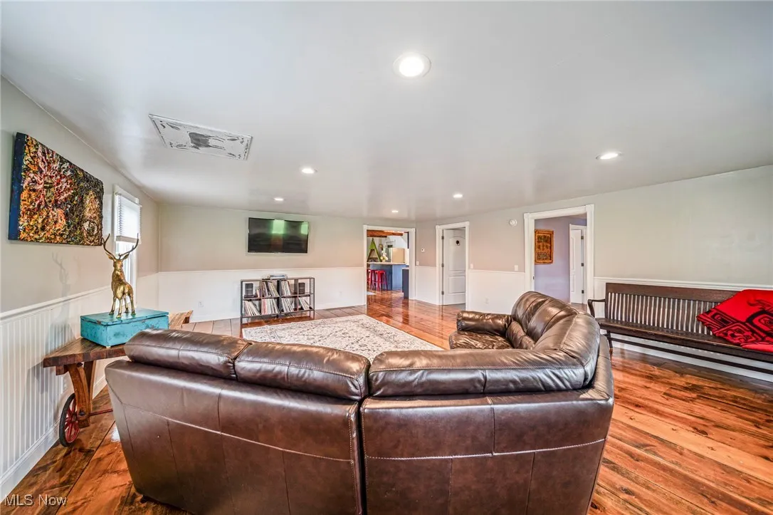 Living room with hardwood / wood-style flooring, wainscoting, and recessed lighting