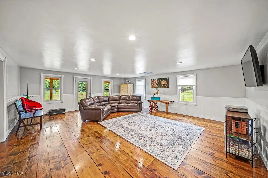 Living room featuring wainscoting, hardwood / wood-style flooring, recessed lighting, and wood walls