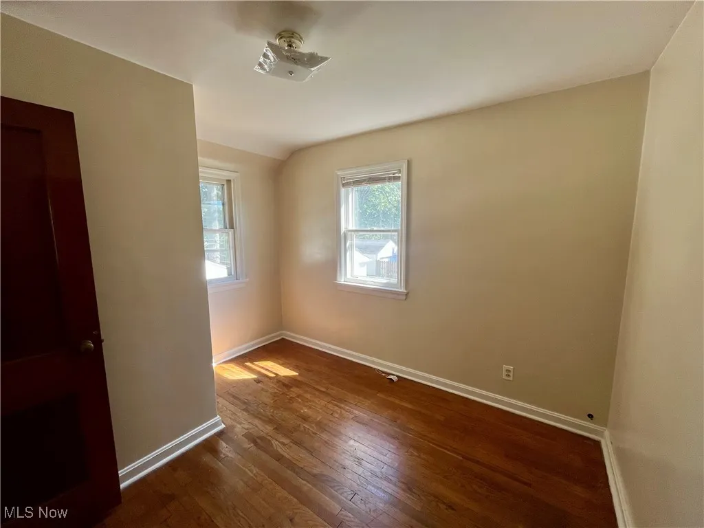 Unfurnished room with wood-type flooring and baseboards