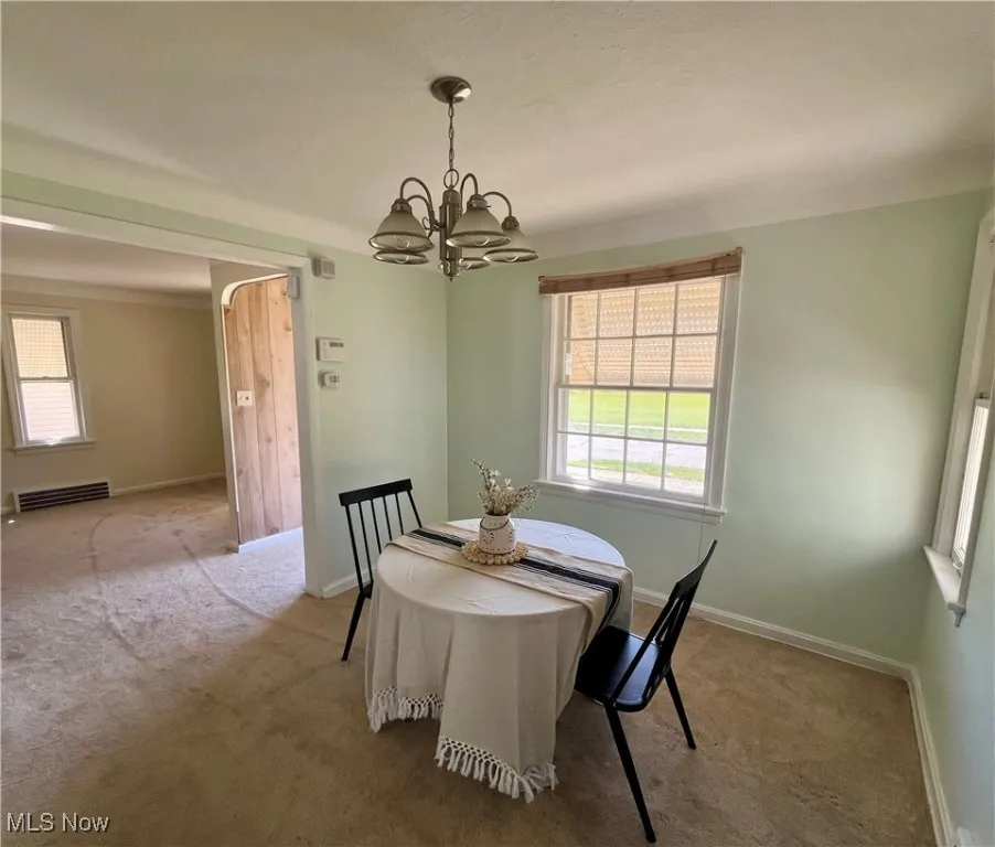 Dining room with carpet flooring and a chandelier