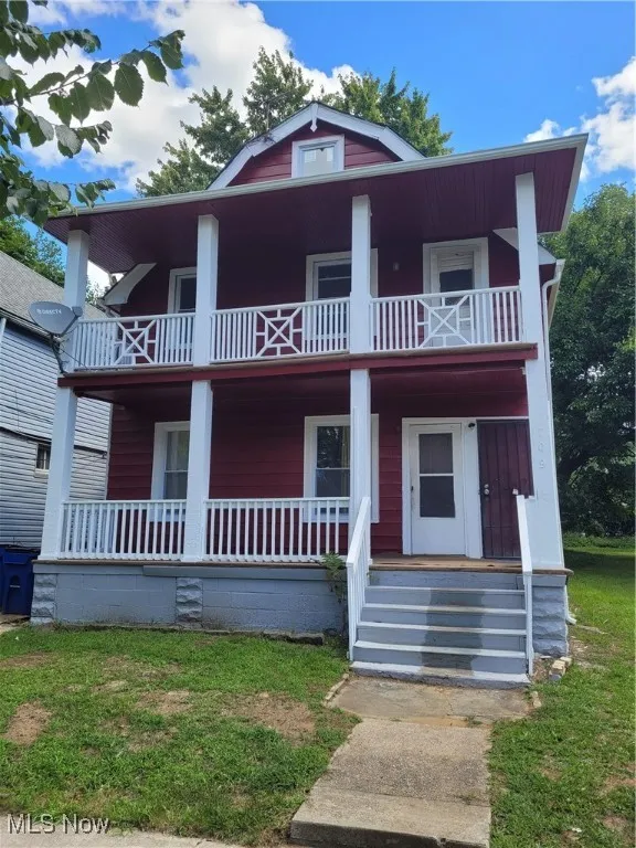 View of front of house with covered porch and a front yard