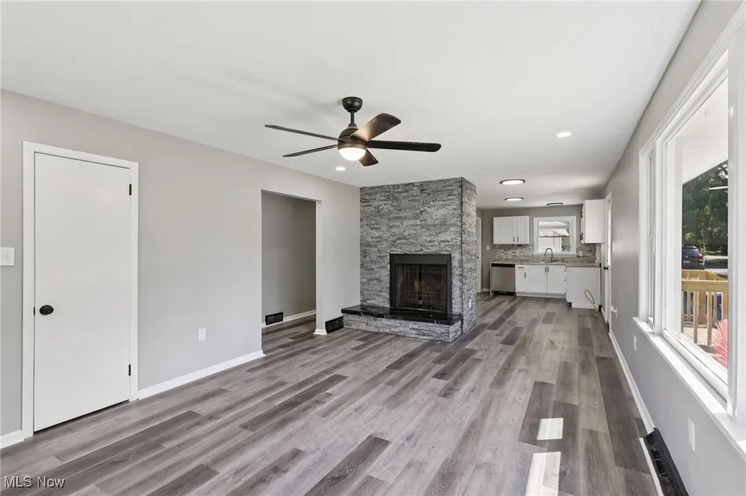 Unfurnished living room with a fireplace, light wood-style floors, ceiling fan, and recessed lighting