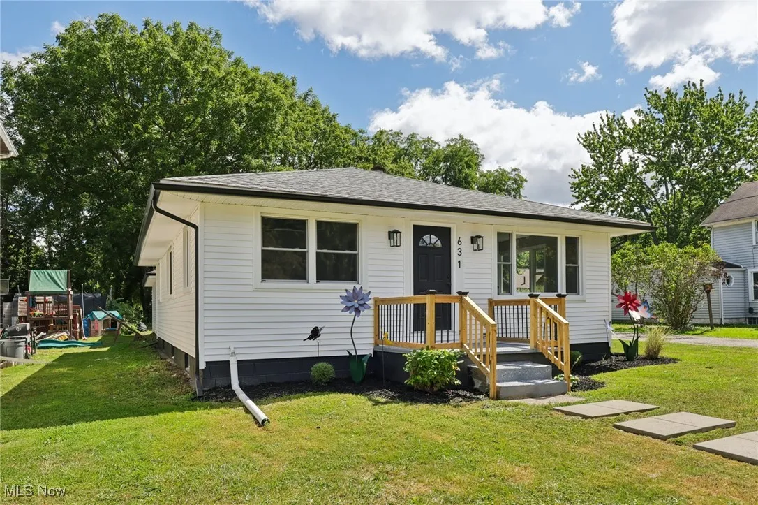View of front of property featuring a front yard and roof with shingles