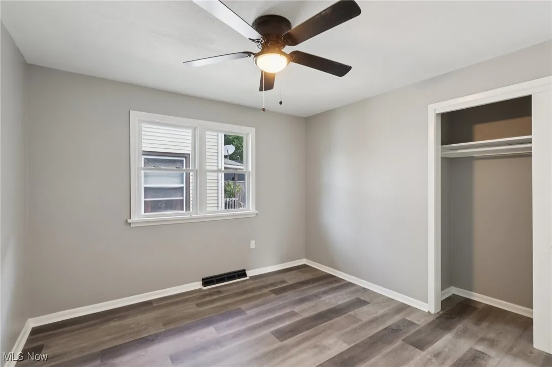 Unfurnished bedroom with wood finished floors, a closet, and ceiling fan