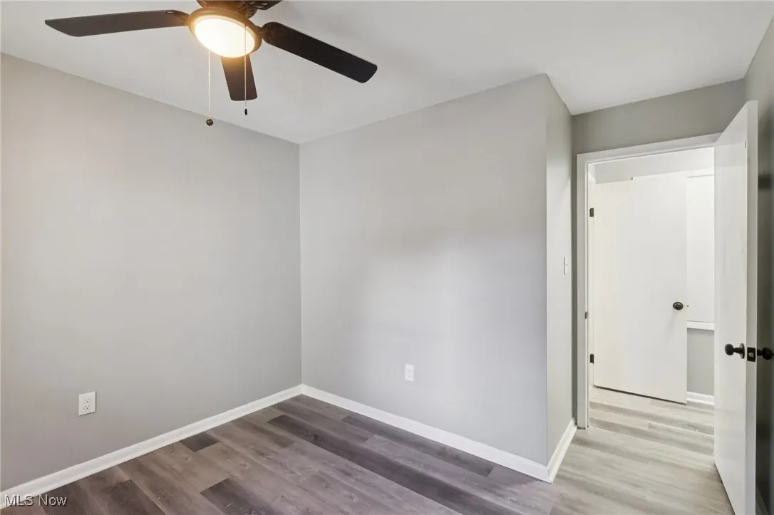Unfurnished room with wood finished floors and a ceiling fan