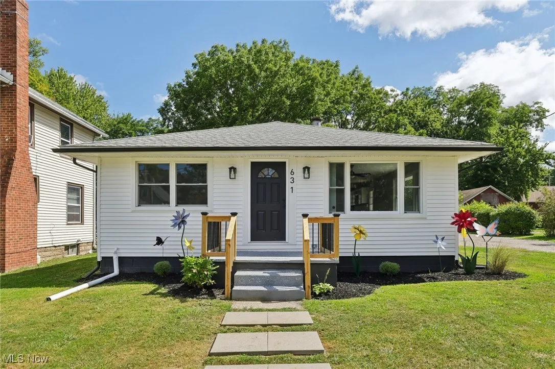 Bungalow featuring a front lawn and roof with shingles