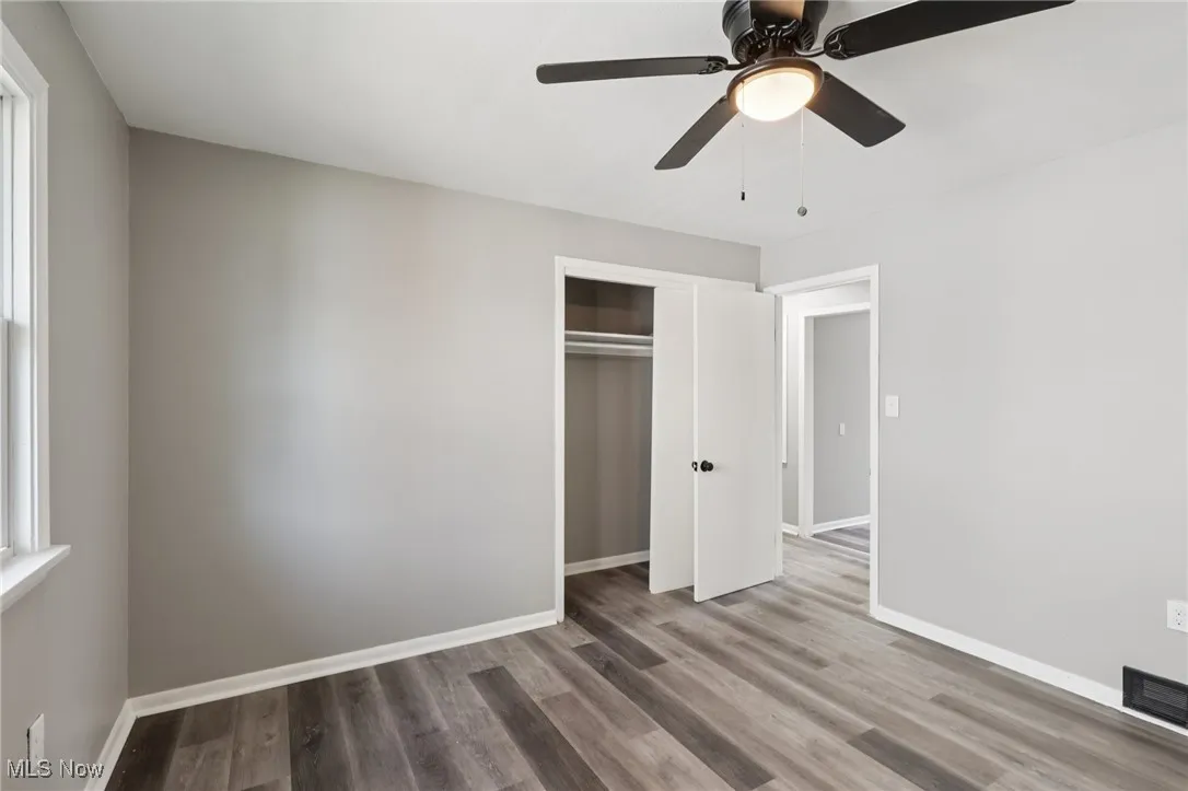 Unfurnished bedroom with wood finished floors, a ceiling fan, and a closet
