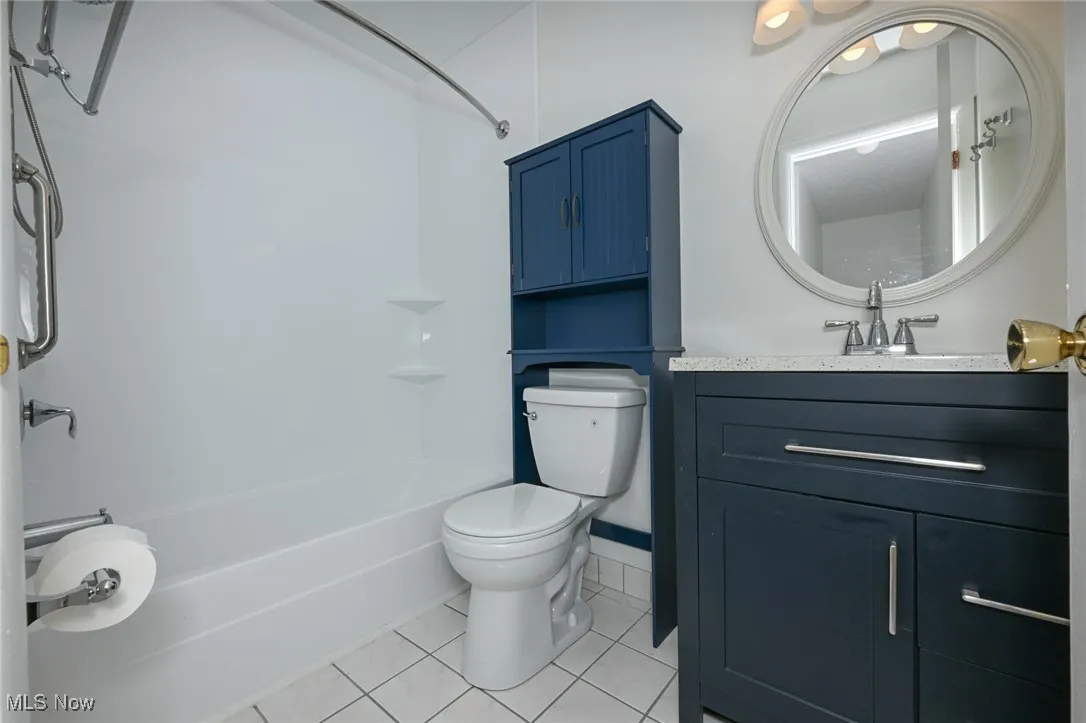 Upstairs full bath with shower / tub combination, light tile patterned floors, and vanity
