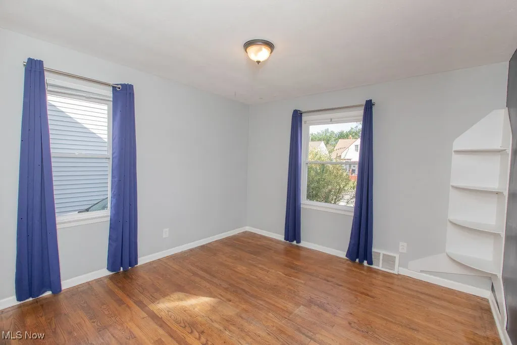 Spare room featuring wood finished floors and baseboards