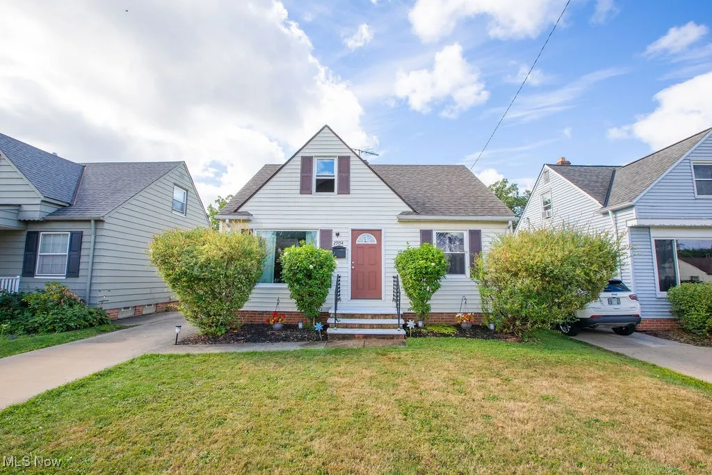 View of front of home featuring a front lawn and roof with shingles