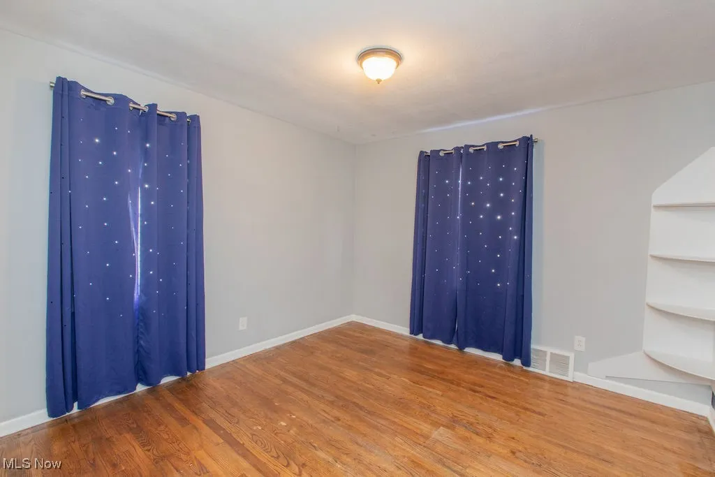 Empty room with wood finished floors and baseboards