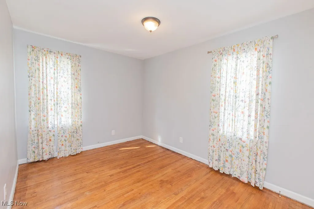 Unfurnished room with light wood-style flooring and baseboards