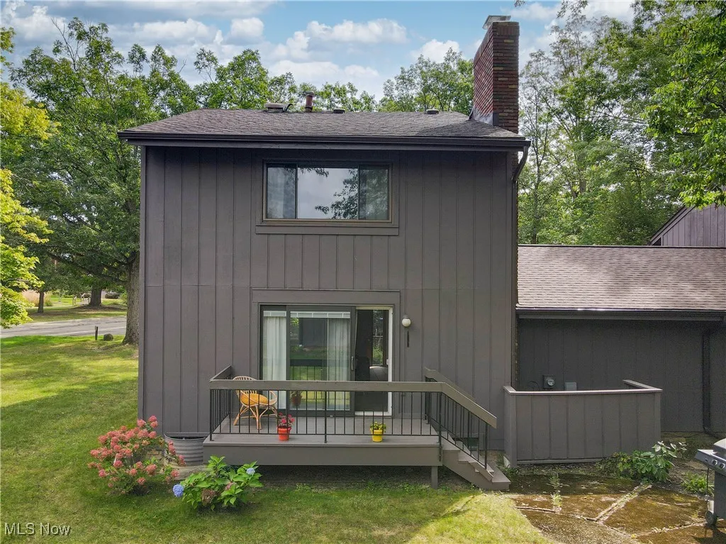 Rear view of property featuring a nice deck and a yard area - grill is included