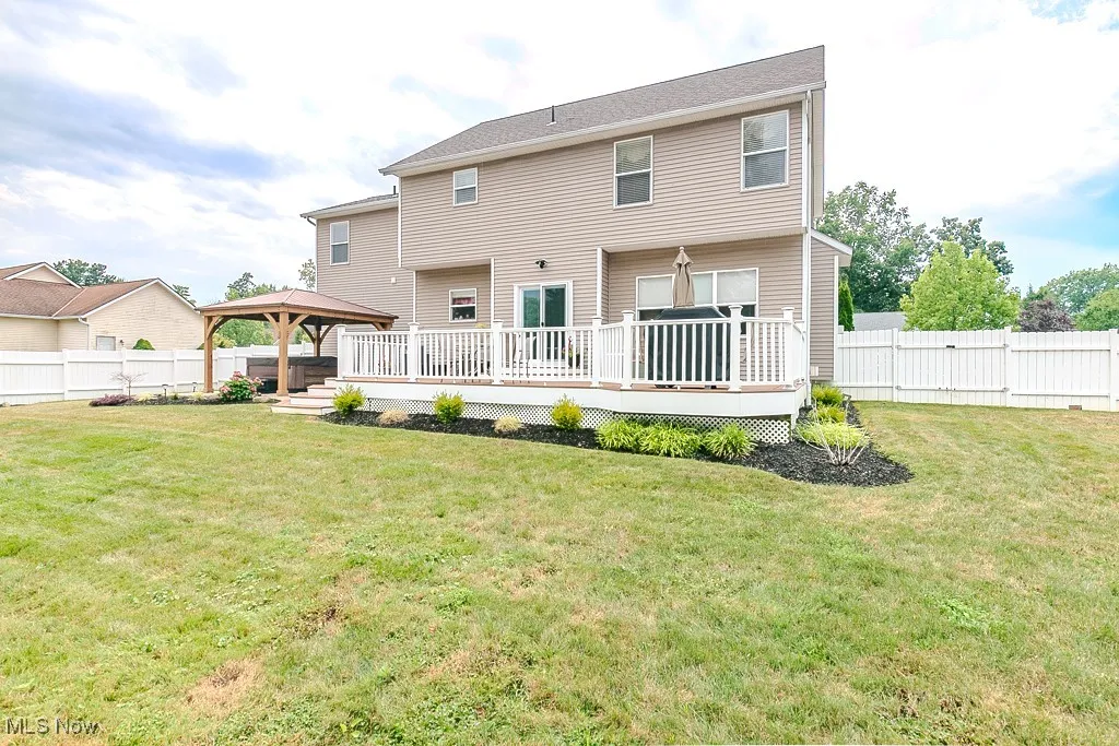 Back of property featuring a gazebo, a fenced backyard, a deck, and a patio