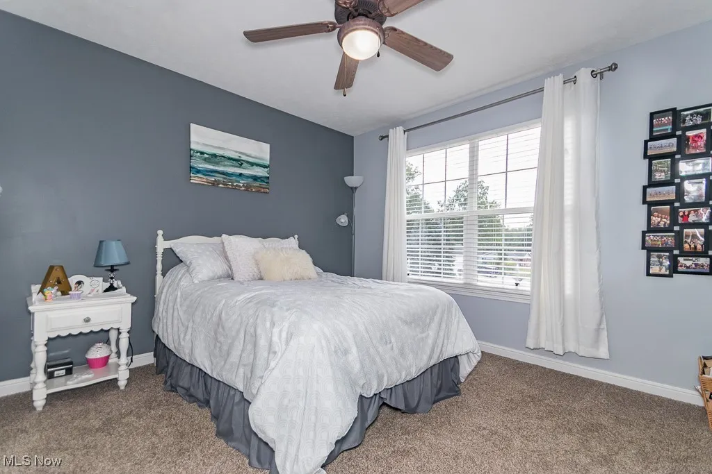 Carpeted bedroom with baseboards and ceiling fan