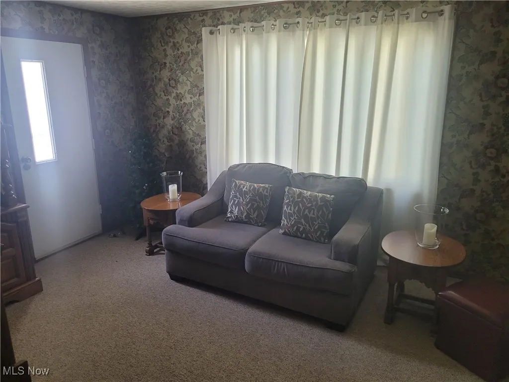 Living area with wallpapered walls and carpet