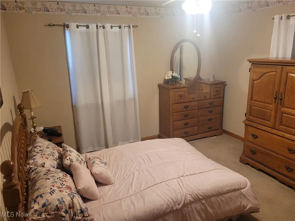 Bedroom featuring light carpet and baseboards