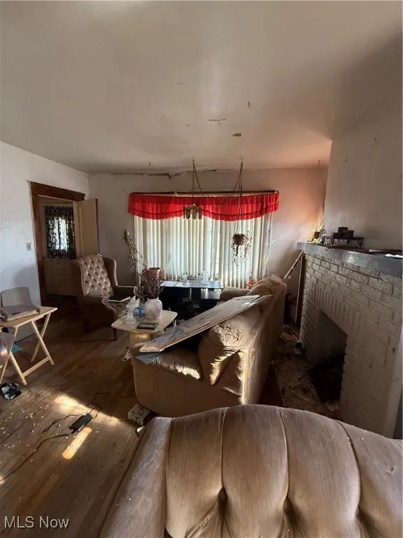 Dining area with wood-type flooring and a brick fireplace