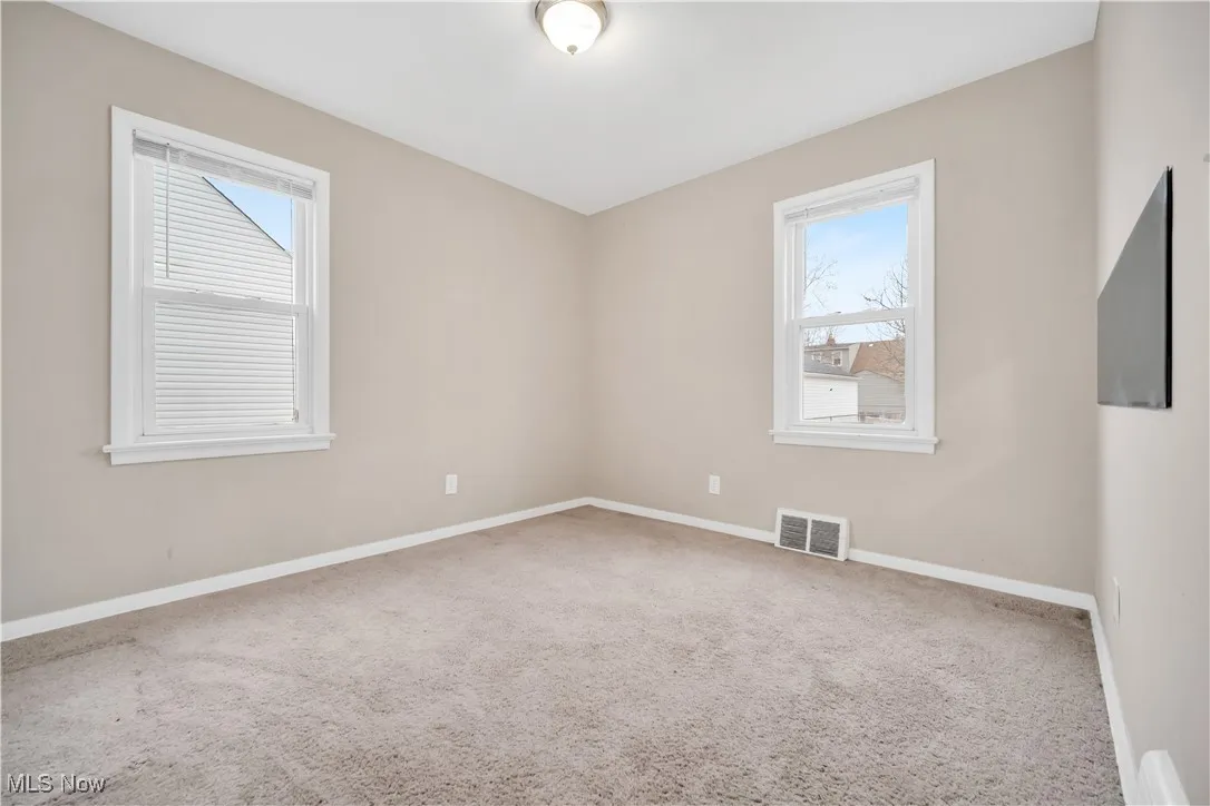 Spare room with baseboards, visible vents, and carpet floors