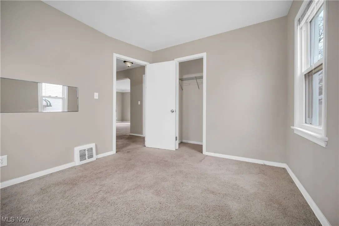 Unfurnished bedroom with a closet, visible vents, baseboards, and carpet floors