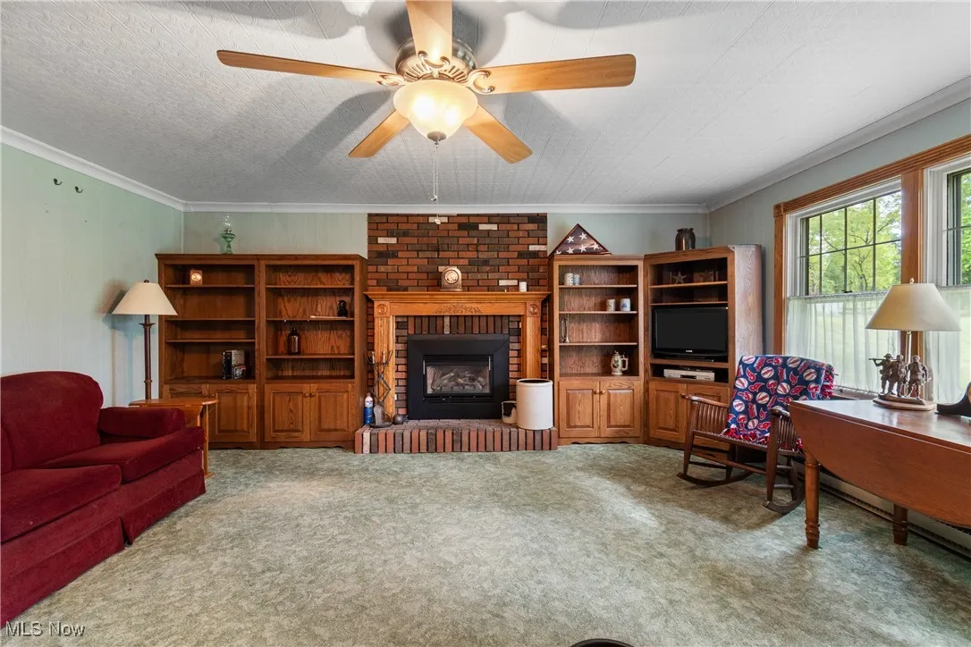 Family room with a fireplace and ceiling fan