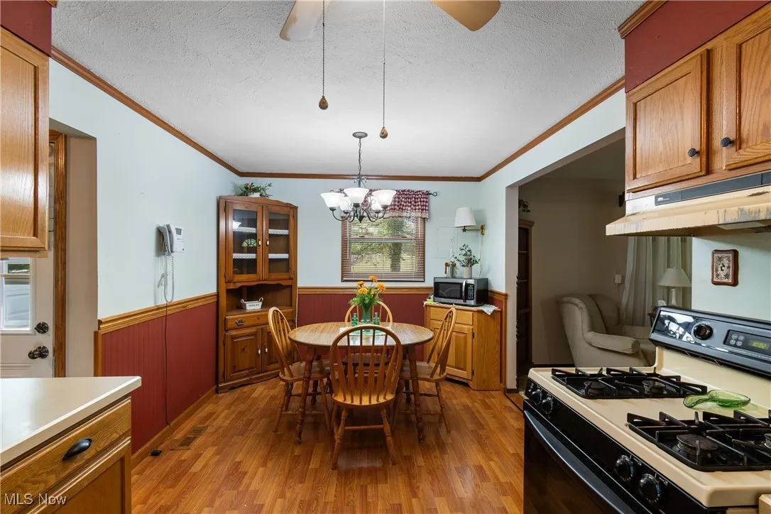 Kitchen featuring gas stove, oak cabinets and crown molding