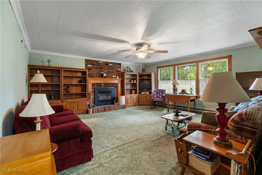Family room with
a fireplace and a ceiling fan