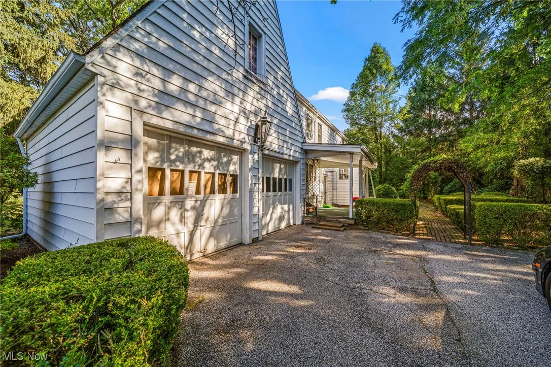 View of side of home featuring driveway and a garage