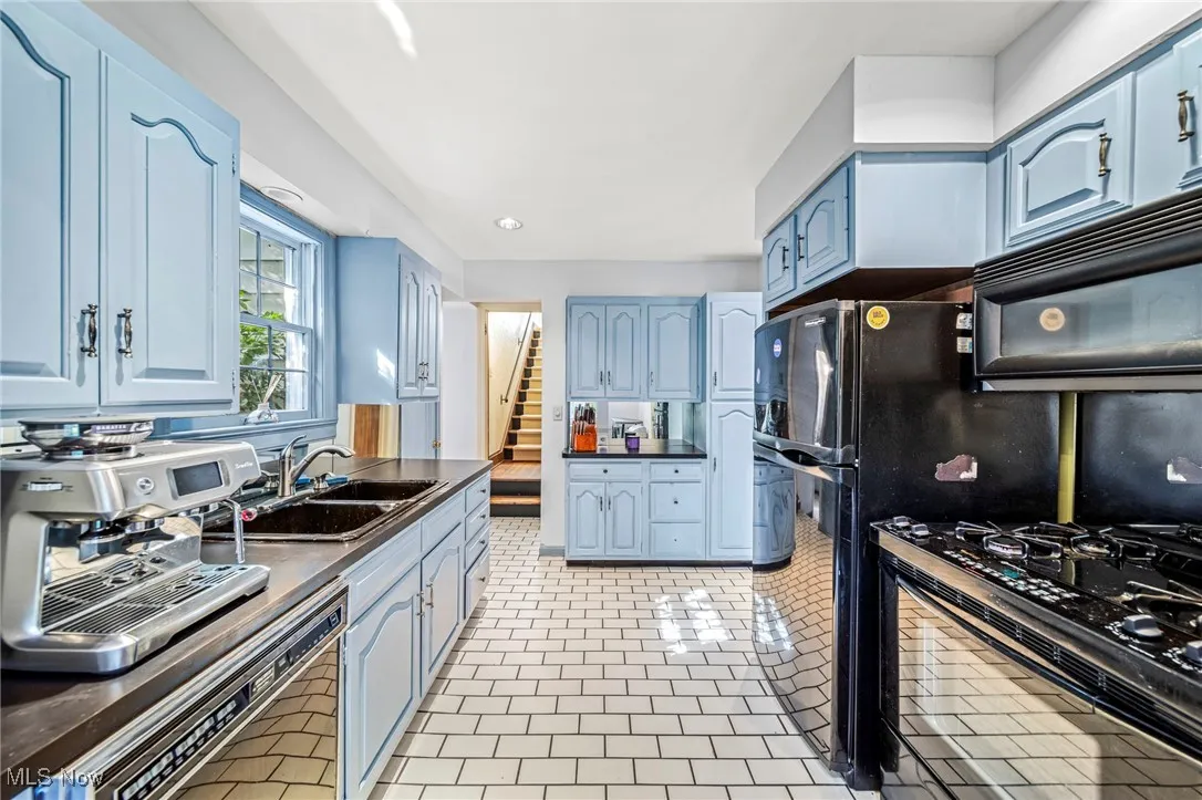 Kitchen featuring black appliances, blue cabinets, recessed lighting, and light tile patterned flooring