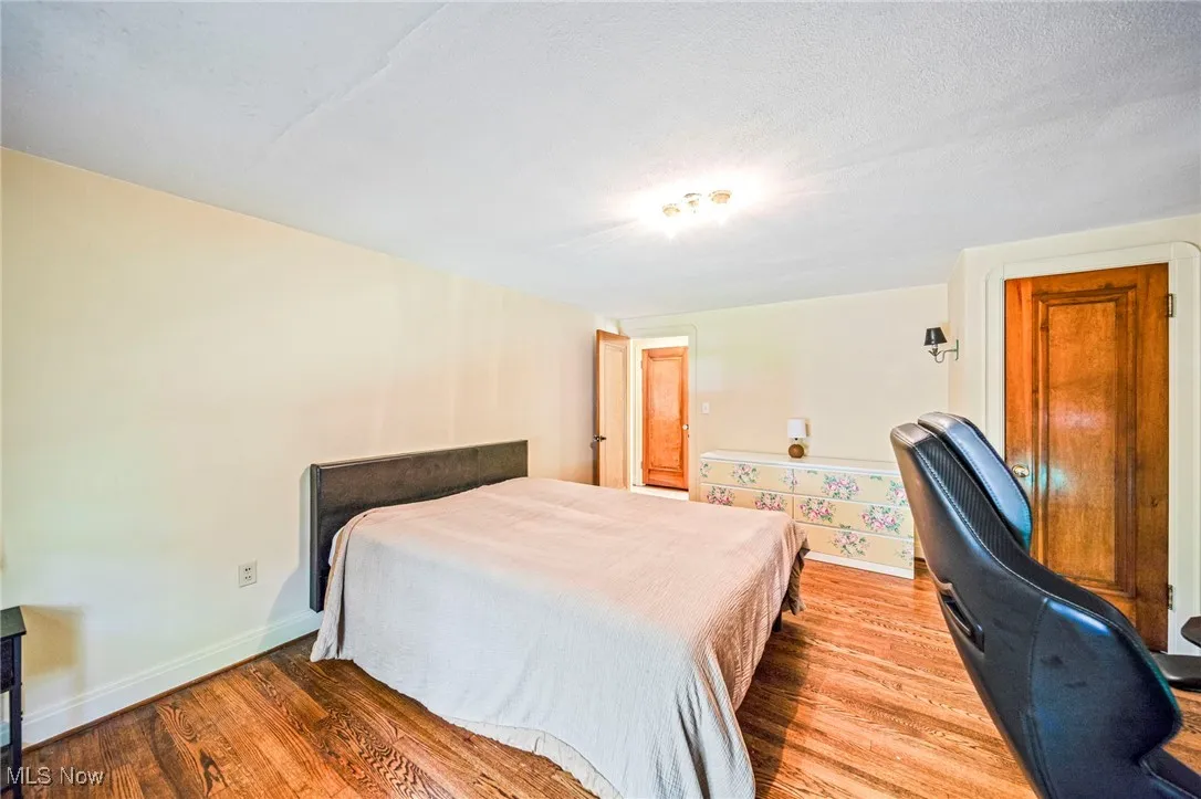 Bedroom with wood finished floors and a textured ceiling