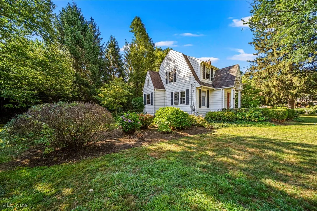 View of front of property featuring a gambrel roof and a front yard