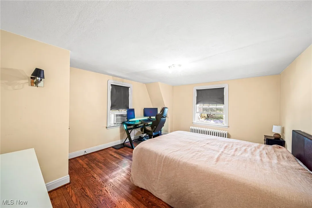 Bedroom featuring dark wood-type flooring and radiator