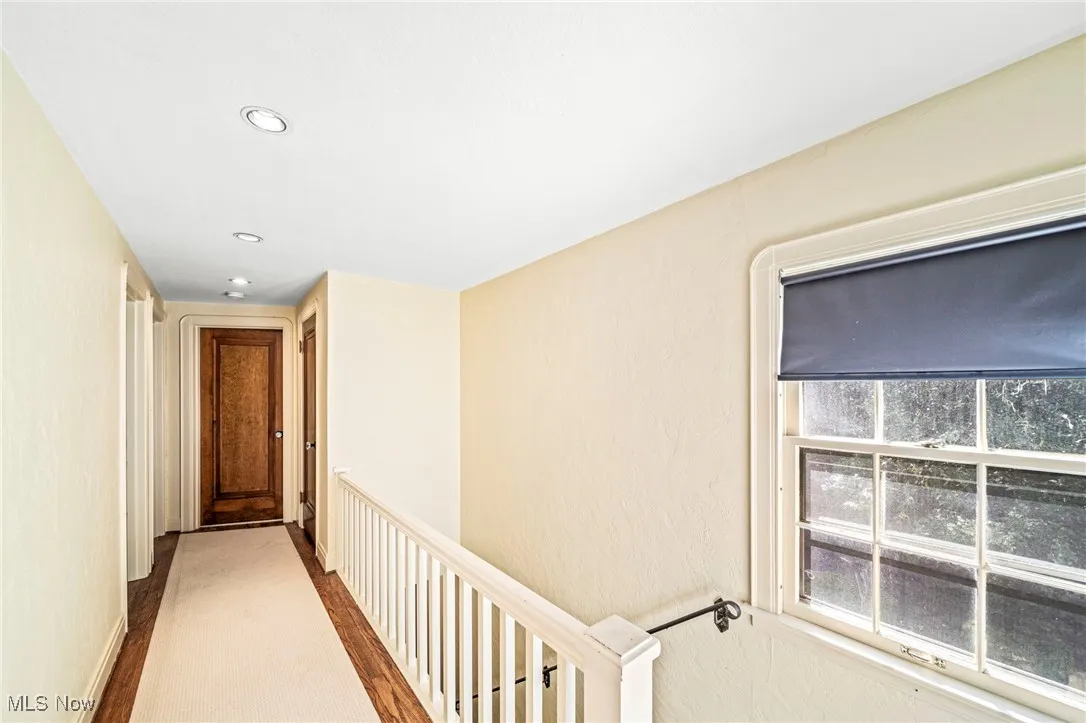 Hallway with recessed lighting and an upstairs landing