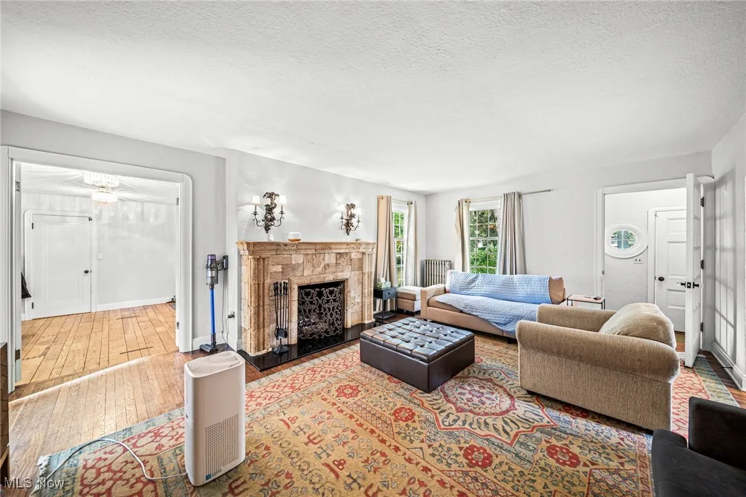 Living area with a tile fireplace, wood-type flooring, and a textured ceiling