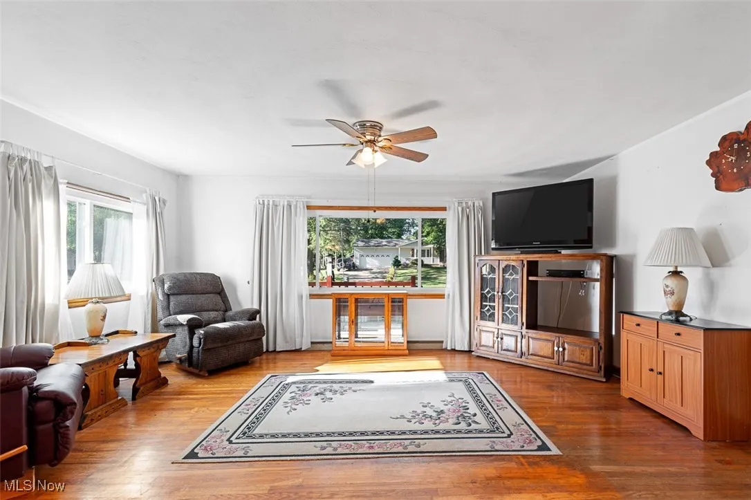 Living room with light wood-style floors and a ceiling fan
