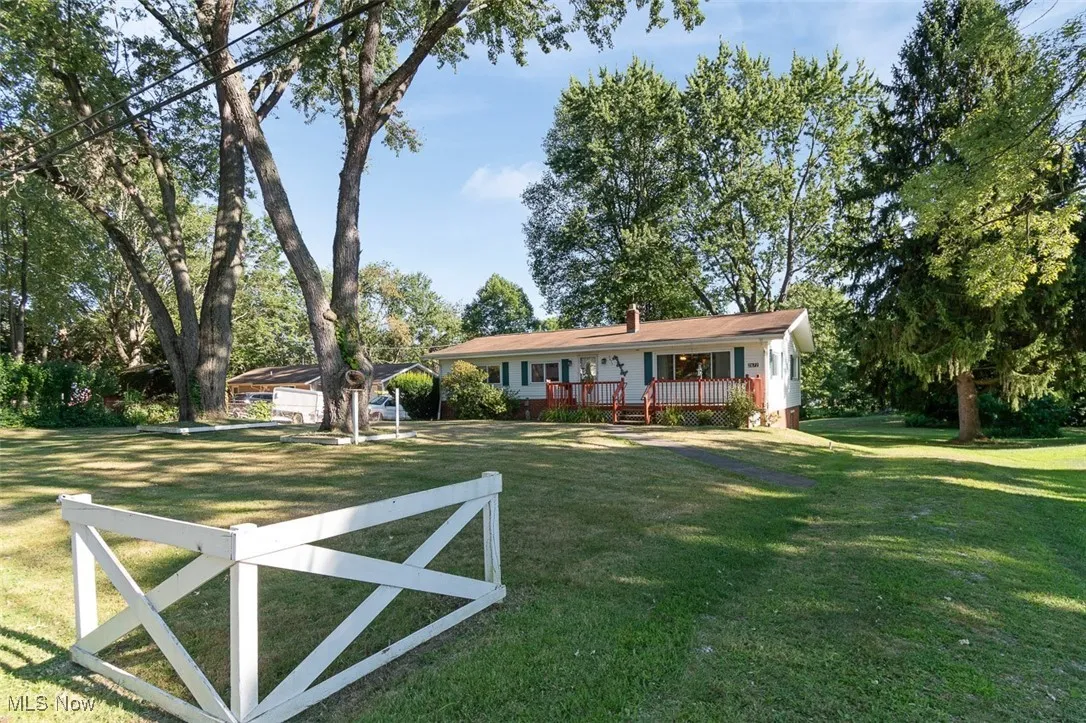 View of front facade featuring a front lawn and a chimney