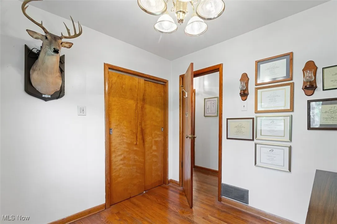 Bedroom with wood finished floors and a chandelier