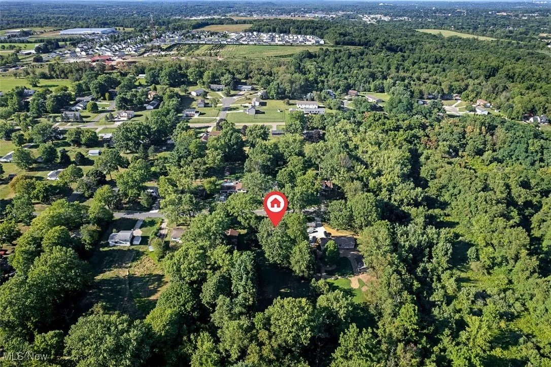 View of property location with a heavily wooded area