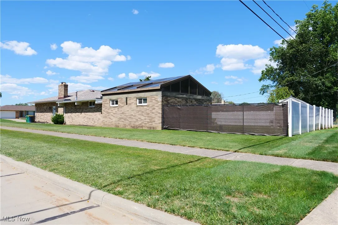 View of home's exterior featuring brick siding and a chimney