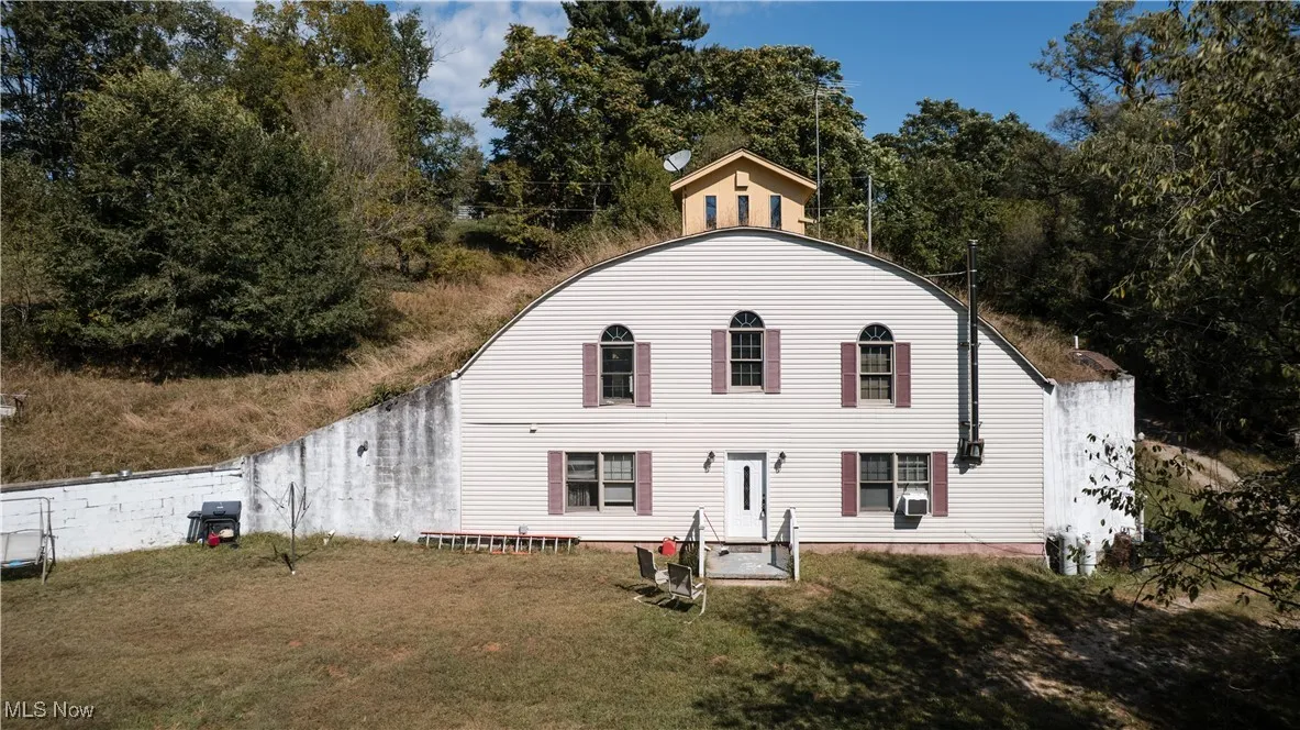 Rear view of house featuring a lawn