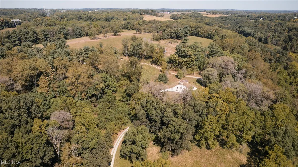 Aerial view of property's location with a heavily wooded area