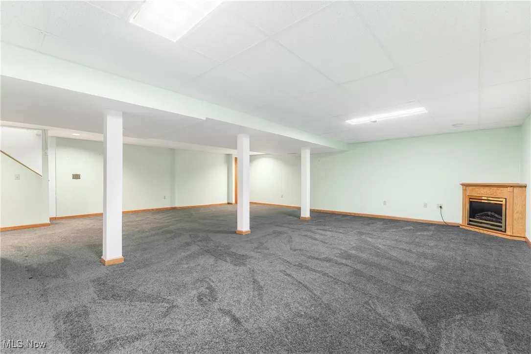 Finished basement with a paneled ceiling and carpet